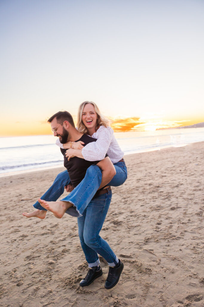 Victoria and Jonathan walking along Butterfly Beach during sunset engagement photos in Santa Barbara.