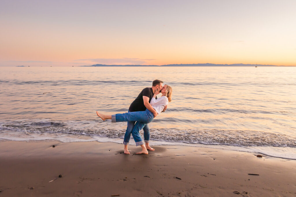 Victoria and Jonathan walking along Butterfly Beach during sunset engagement photos in Santa Barbara.