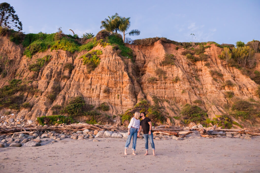 Victoria and Jonathan walking along Butterfly Beach during sunset engagement photos in Santa Barbara.