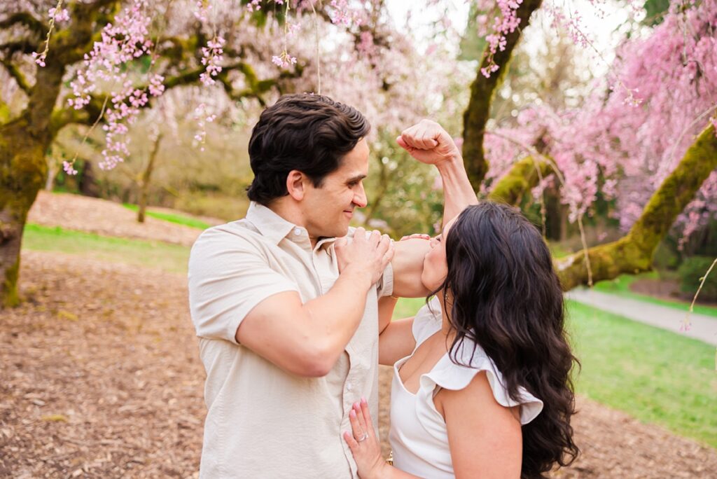 Seattle engagement photos at Washington Park Arboretum with cherry blossoms and couple embracing