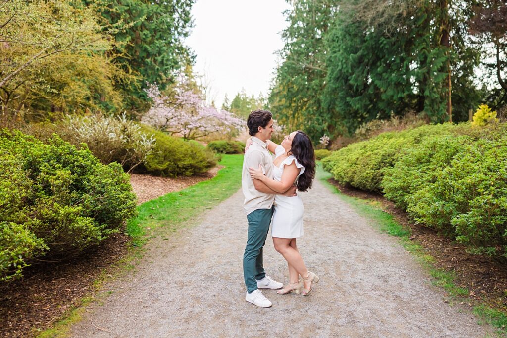 Seattle engagement photos at Washington Park Arboretum with cherry blossoms and couple embracing