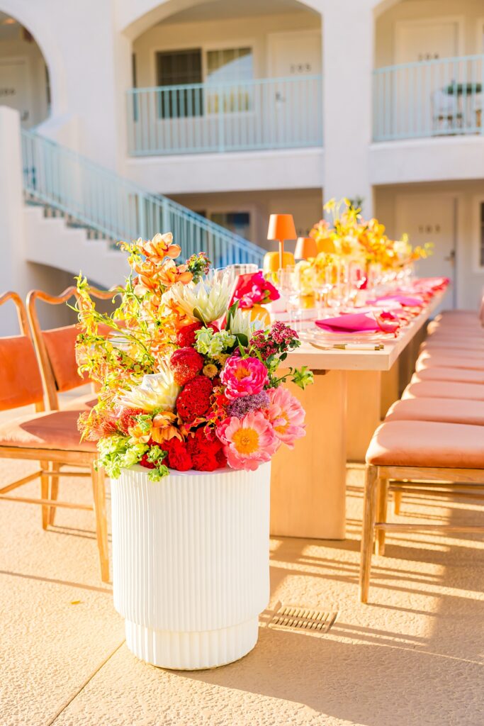 Colorful poolside reception table design at Casa Palma in Palm Springs with vibrant florals and pink details
